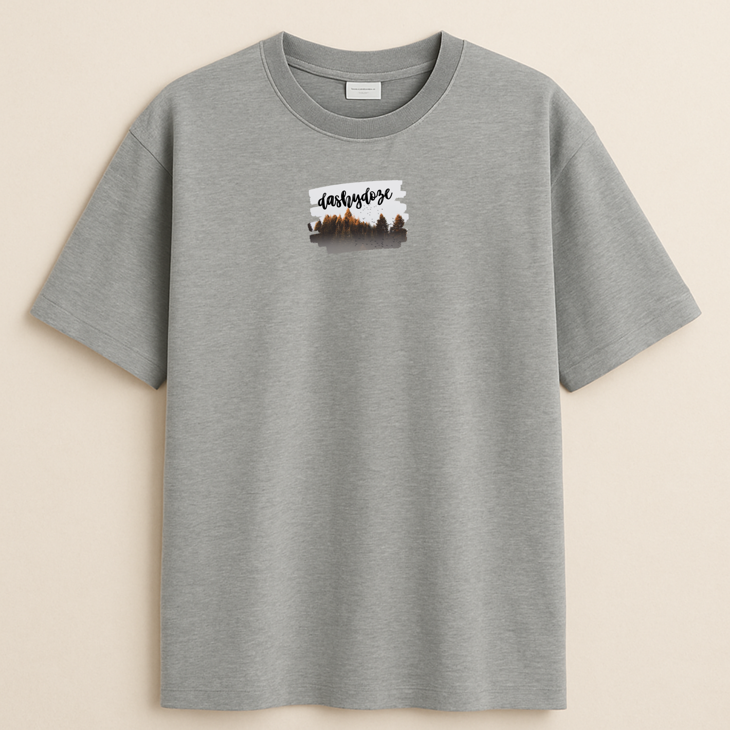 Gray t-shirt with a small graphic on the chest against a beige background